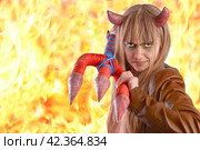 Girl in the guise of a devil with a trident on the background of fire. Стоковое фото, фотограф Дмитрий Кобзев / Фотобанк Лори