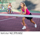 Young forcefully teenage girl playing tennis close to net on court. Стоковое фото, фотограф Яков Филимонов / Фотобанк Лори