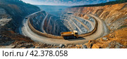 An open-pit mine with a large mining truck driving down the terraces. Heavy machinery in action within the expansive excavation layers. Panorama with copy space. Стоковое AI-изображение, AI-художник Igor Tichonow / Фотобанк Лори