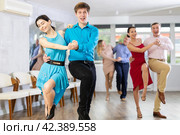 Cheerful young couple dancing playful jitterbug in dance studio. Стоковое фото, фотограф Яков Филимонов / Фотобанк Лори