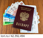 Российский паспорт, билет на самолет и деньги лежат на столе (2024 год). Редакционное фото, фотограф Анна Аникова / Фотобанк Лори
