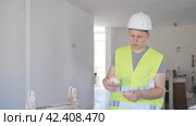 Portrait of teenage boy wearing yellow vest and hardhat holding bunch of earned money for part-time work in construction site. Стоковое видео, видеограф Яков Филимонов / Фотобанк Лори