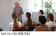 Group of friendly women of different ages sitting around table and communicating in Spanish-speaking club with elderly female tutor. Стоковое видео, видеограф Яков Филимонов / Фотобанк Лори