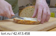 Мужчина намазывает металлическим ножом сливочное масло на отрезанный кусок хлеба. Стоковое видео, видеограф Алексей Афанасьев / Фотобанк Лори