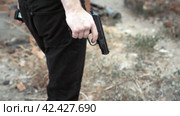 Close-up of a moving man's hand with a gun. Стоковое видео, видеограф EStarodubov / Фотобанк Лори