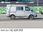 GAZ Sobol 2752 van on city road in motion. Side view of panel van car with blurred urban background (2021 год). Редакционное фото, фотограф Константин Григорьев / Фотобанк Лори