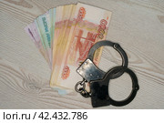 Наручники на фоне российских денег. Стоковое фото, фотограф Руслан Лесков / Фотобанк Лори