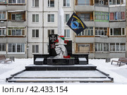 Памятник тындинцам, погибшим в локальных войнах, город Тында, Амурская область, Россия. На чёрном постаменте скульптурная композиция в виде руки, держащей большой меч. На монументе установлен флаг с надписью «Военная разведка. Выше нас только звёзды». (2024 год). Редакционное фото, фотограф Андрей Степанов / Фотобанк Лори