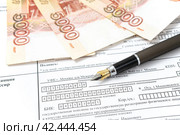 Перьевая ручка и российские деньги лежат на квитанции об оплате (2024 год). Редакционное фото, фотограф Андрей Бойков / Фотобанк Лори