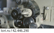 Close-up of a 35mm cine-film in movie projector. Clamping guide rollers and gear drums. Стоковое видео, видеограф EStarodubov / Фотобанк Лори