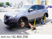 Nissan Qashqai wheels replacement. Lifting car and changing wheels using trolley jack (2023 год). Редакционное фото, фотограф FotograFF / Фотобанк Лори