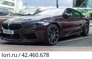 BMW M8 Competition Gran Coupe in Ametrin metallic color parked on the city street. Front side view of 4-door fastback sedan. Редакционное фото, фотограф Константин Григорьев / Фотобанк Лори