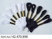 Many black and white skeins of mouline thread for embroidery on a row in circle on whitebackground. Стоковое фото, фотограф Татьяна Терехина / Фотобанк Лори