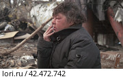 Бомж, бездомная женщина бродяга. Homeless woman vagabond in a temporary place smoking a cigarette. Стоковое видео, видеограф EStarodubov / Фотобанк Лори