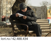 Пожилой человек сидя на лавочки в сквере аннотацию к лекарству. Липецк. (2024 год). Редакционное фото, фотограф Евгений Будюкин / Фотобанк Лори