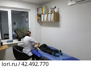 Доктор центра Бубновского осматривает позвоночник ребёнка (2024 год). Редакционное фото, фотограф Дмитрий Неумоин / Фотобанк Лори