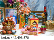 Orthodox Easter. Easter cake, painted eggs, cahors wine and Easter decor on the table in an old village house. (2014 год). Редакционное фото, фотограф Photojuli / Фотобанк Лори