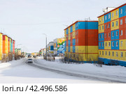 Город Анадырь, Чукотский автономный округ, Российская Федерация. Зимний городской пейзаж. Вид на заснеженную улицу и красочные разноцветные здания. По дороге едет автомобиль. Современный благоустроенный город на Дальнем Востоке России в Арктике. Редакционное фото, фотограф Андрей Степанов / Фотобанк Лори