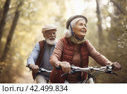 Senior couple riding bicycles together in the park. Generate ai. Стоковое AI-изображение, AI-художник Иван Рябоконь / Фотобанк Лори