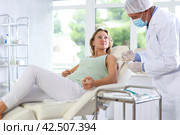 Blurry mature male nurse gives injection, injects vaccine into shoulder of woman patient of clinic. Стоковое фото, фотограф Яков Филимонов / Фотобанк Лори