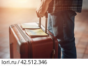 Person tourist holding suitcase and passport document. Generate ai. Стоковое AI-изображение, AI-художник Иван Рябоконь / Фотобанк Лори