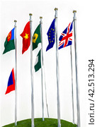 Flags different countries on high flagpoles. National flag different fluttering in wind. Flag Korea, Russia, United States, India, Vietnam, Cambodia and other against blue sky. Natural vertical photo. Стоковое AI-изображение, AI-художник Aleksandr Golubev / Фотобанк Лори