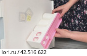 A woman makes an overview of a wall dispenser for a toothpaste with a holder for toothbrushes. Installs a tube of toothpaste. Vertical video. Стоковое видео, видеограф Vadzim Yakubovich / Фотобанк Лори