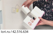 A woman makes an overview of a wall dispenser for a toothpaste with a holder for toothbrushes. Vertical video. Стоковое видео, видеограф Vadzim Yakubovich / Фотобанк Лори