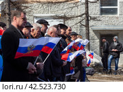 Люди с российскими флагами идут по улице. Шествие во время первомайской демонстрации. Магадан, Магаданская область, Россия. (2018 год). Редакционное фото, фотограф Андрей Степанов / Фотобанк Лори
