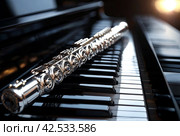 Flute with piano. Flute on piano keys. Wind instrument for musical design of concert creativity. Стоковое AI-изображение, AI-художник Aleksandr Golubev / Фотобанк Лори