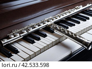 Flute with piano. Flute on piano keys. Wind instrument for musical design of concert creativity. Стоковое AI-изображение, AI-художник Aleksandr Golubev / Фотобанк Лори