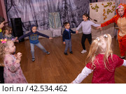 Аниматор играет с детьми из многодетных семей на праздничном мероприятии, организованном благотворительной организацией. The animator plays with children from large families at a festive event organized by a charity organization. (2021 год) Редакционное фото, фотограф Мария / Фотобанк Лори