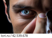 Diligent Man holding contact lens closeup. Generate Ai. Стоковое AI-изображение, AI-художник Иван Рябоконь / Фотобанк Лори