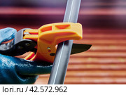 Cutting HDPE pipes with ratcheting pipe scissor cutter when installing an external water supply system. Стоковое фото, фотограф Владимир Григорьев / Фотобанк Лори