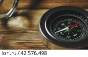 Close-Up of a Classic Compass Beside a Rope on a Wooden Surface During Daylight. Стоковое видео, видеограф Сергей Толмачёв / Фотобанк Лори