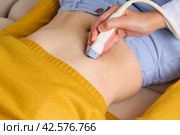 Faceless doctor doing ultrasound scanning of right lobe, gallbladder, liver and bile ducts. Стоковое фото, фотограф Natalia Gdovskaia / Фотобанк Лори