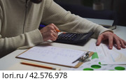 Man Calculating Budget With Calculator and Paperwork at Home Office Desk. Стоковое видео, видеограф Сергей Толмачёв / Фотобанк Лори