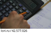 Person Calculating Budget on Electronic Calculator With Handwritten Notes in Office Environment. Стоковое видео, видеограф Сергей Толмачёв / Фотобанк Лори