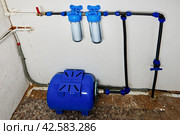Reverse osmosis diaphragm storage tank, pressure accumulator and cartridges with rope filters in home water supply system in utility room. Стоковое фото, фотограф Владимир Григорьев / Фотобанк Лори