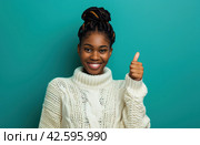 ctp afroamerican young woman in white sweater with thumbs up while pointing to right. Стоковое AI-изображение, AI-художник Юлия Гапеенко / Фотобанк Лори