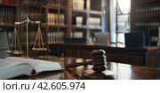 Books on jurisprudence, a judge's hammer and scales in the judge's office. The concept of justice. Стоковое AI-изображение, AI-художник Ярославский Максим / Фотобанк Лори