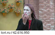 Мим ест большой сочный фрукт. Mime imitates an imaginary eat big juicy fruit. Стоковое видео, видеограф EStarodubov / Фотобанк Лори