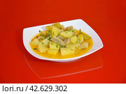 Тушенная картошка с мясом в белой тарелке на красном зеркальном фоне. Стоковое фото, фотограф Михаил Киселев / Фотобанк Лори