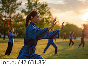 Girls in blue kimonos practice oriental martial arts in a forest clearing. Practice kung fu. Стоковое AI-изображение, AI-художник Ярославский Максим / Фотобанк Лори