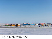 Чукотское село Тавайваам, Чукотка, Россия. Вид на небольшой арктический посёлок на берегу замёрзшего моря. Красочные здания в благоустроенном северном поселении. Село Тавайваам входит в состав городского округа Анадырь. (2023 год). Редакционное фото, фотограф Андрей Степанов / Фотобанк Лори