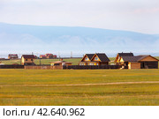 BAIKAL LAKE, OLKHON ISLAND, KHARANTSY VILLAGE, IRKUTSK REGION, RUSSIA - August 15, 2023: View of wooden rural houses in village of Kharantsy on shore of lake on sunny summer day at sunset. Редакционное фото, фотограф Виктория Катьянова / Фотобанк Лори