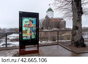 Селфи-киоск с Петром Первым на фоне Выборгского замка. Город Выборг Ленинградской области (2024 год). Редакционное фото, фотограф Румянцева Наталия / Фотобанк Лори