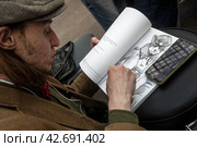 Художник Алексей Трошин подписывает для читателей свою книгу комиксов "Диптих" (2024 год). Редакционное фото, фотограф Николай Винокуров / Фотобанк Лори