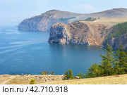 Baikal Lake in summer. Scenic landscape of northern coast of Olkhon Island. View from Cape Sagan-Khushun to Cape Damnuriy. Couple of tourists travel along island. Natural background. Summer holidays. Стоковое фото, фотограф Виктория Катьянова / Фотобанк Лори