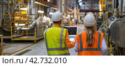 A panoramic banner with two engineers in protective helmets and yellow vests in the production room. They check the data on the laptop. Стоковое AI-изображение, AI-художник Ярославский Максим / Фотобанк Лори